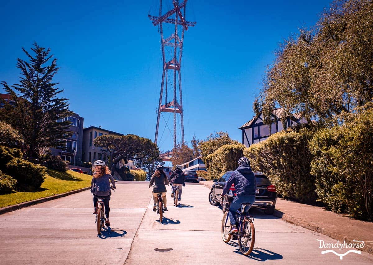 Group riding rented electric bikes up a hill to a San Francisco landmark