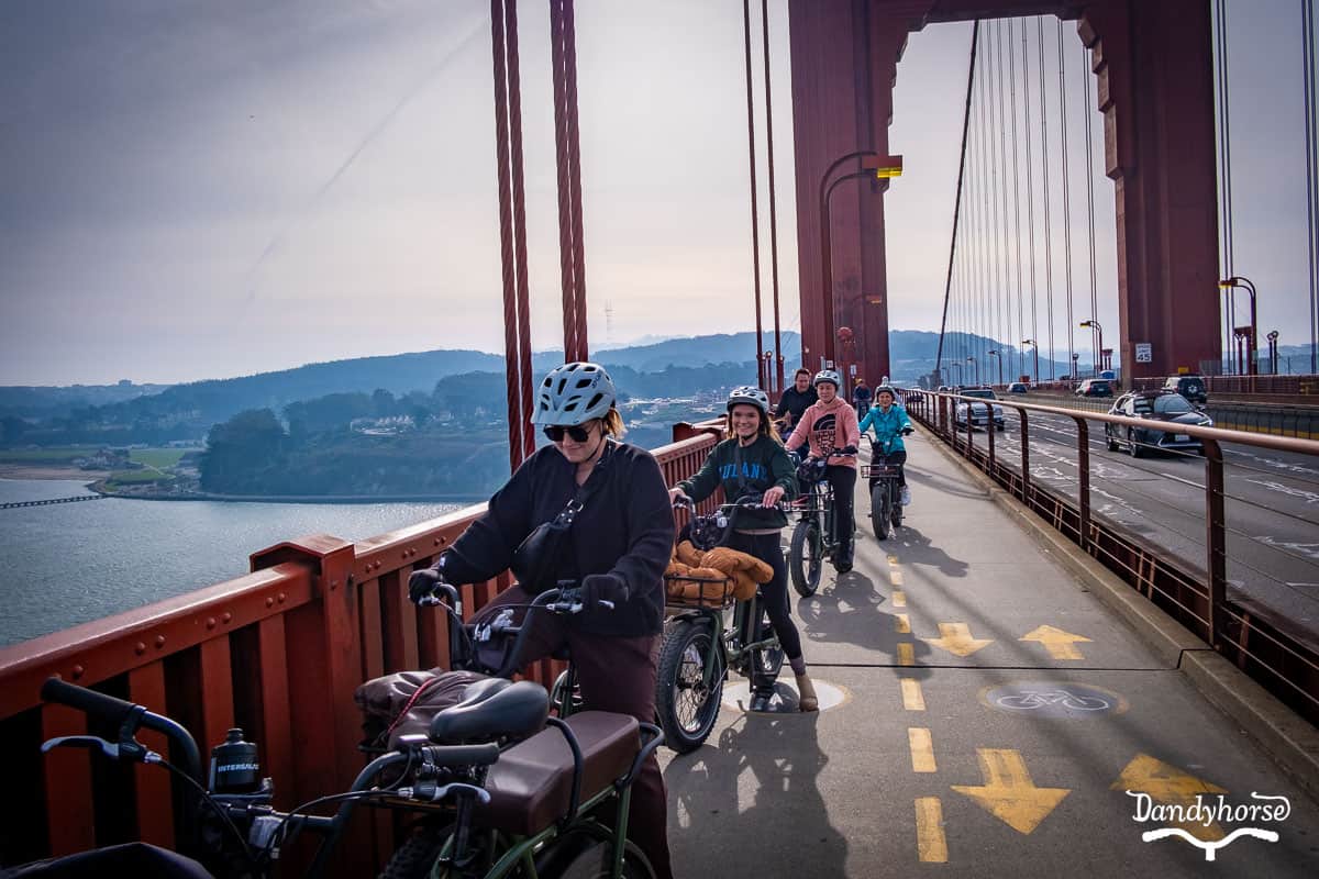 A family riding the Golden Gate Bridge on rented electric bikes