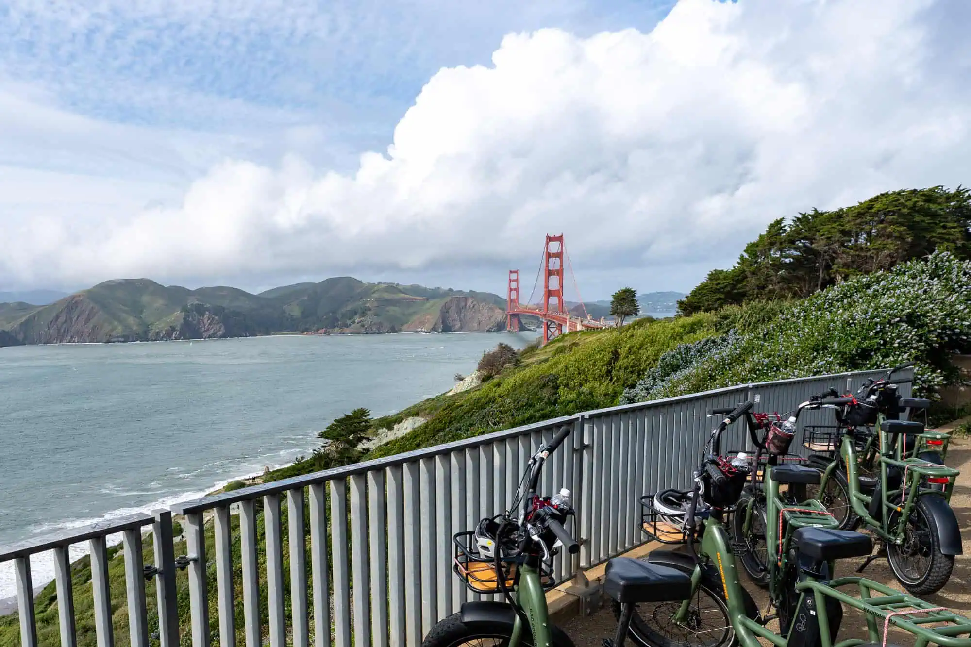 Electric bikes parked at a scenic presidio coastal overlook with a panoramic view of the golden gate bridge and san francisco bay